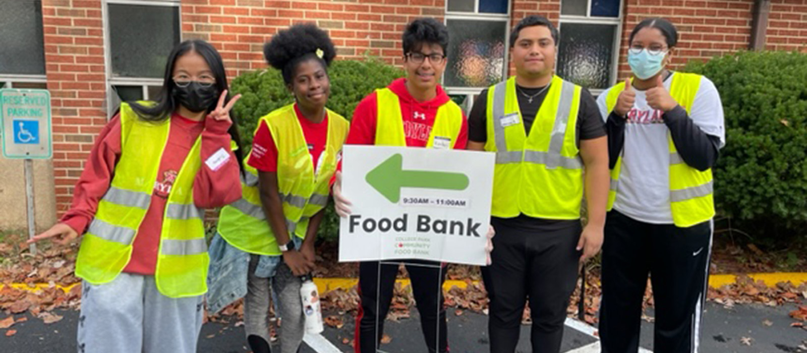 students wearing safety vests pose in front of food bank
